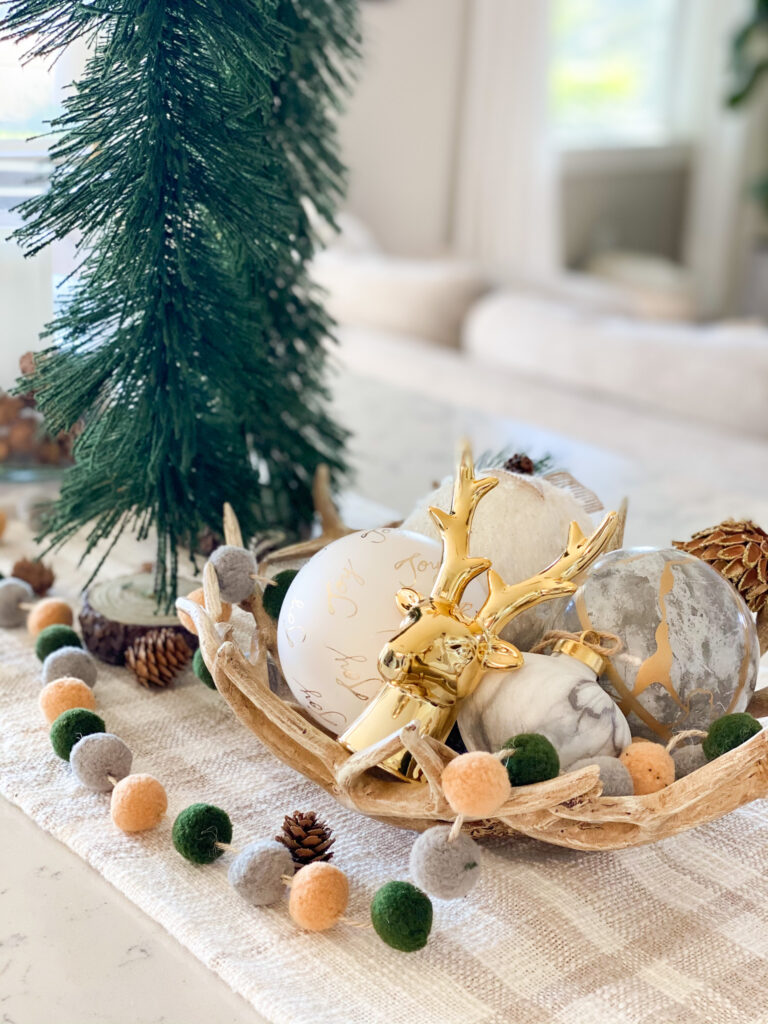 Joann Holiday Decor by popular San Diego life and style blog, Domestic Blonde: image of Joann antler bowl, white and gold ornaments, and a gold deer head and gold embossed pinecone. 