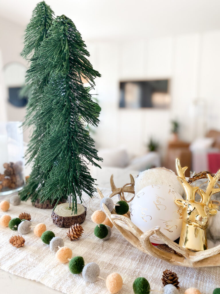 Joann Holiday Decor by popular San Diego life and style blog, Domestic Blonde: image of Joann antler bowl, white and gold ornaments, and a gold deer head and gold embossed pinecone. 