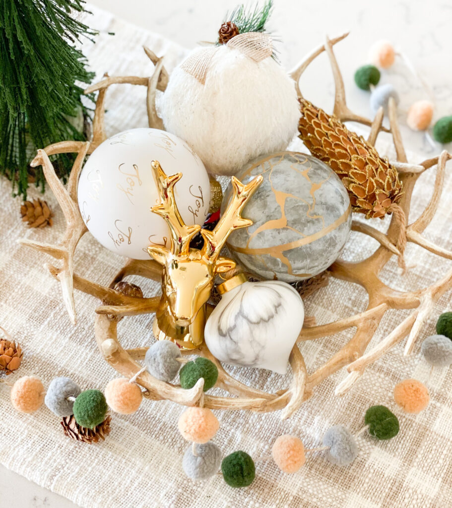 Joann Holiday Decor by popular San Diego life and style blog, Domestic Blonde: image of Joann antler bowl, white and gold ornaments, and a gold deer head and gold embossed pinecone. 