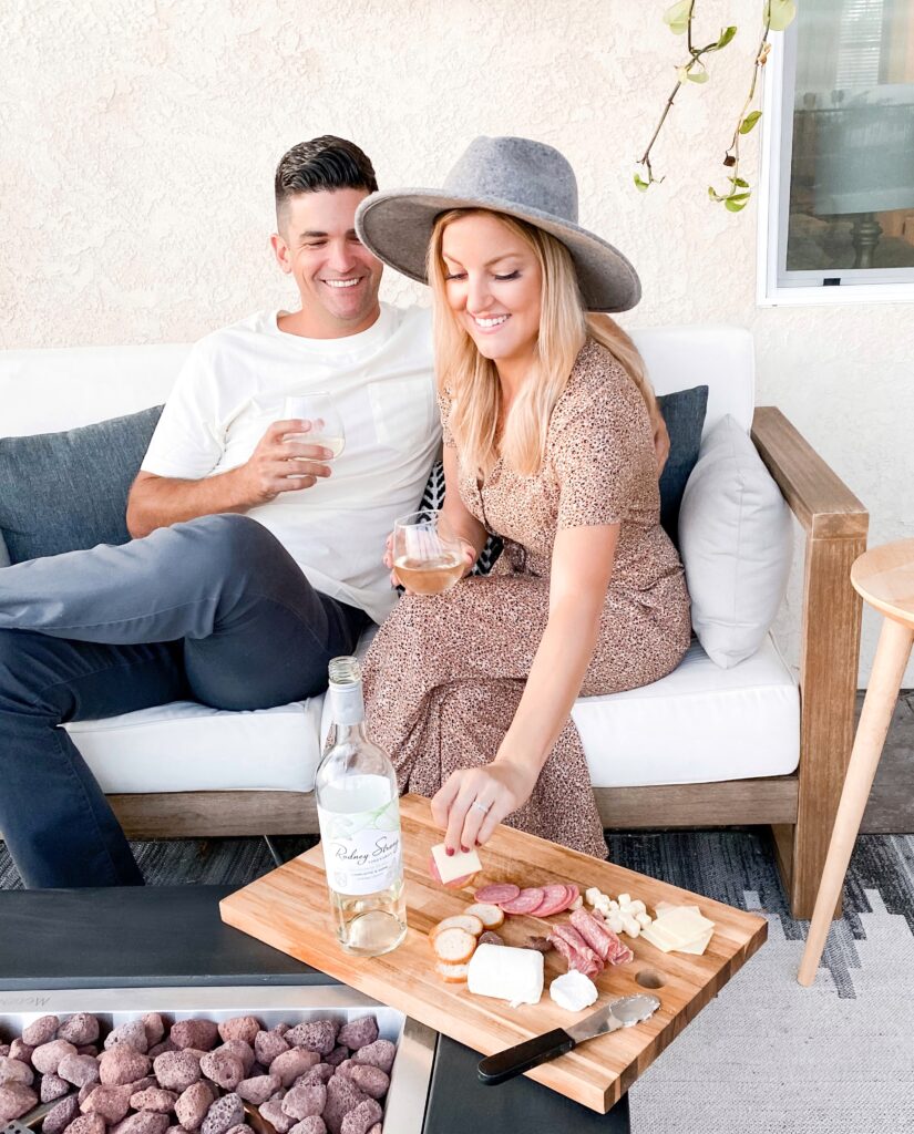 Rodney Strong Wines by popular San Diego lifestyle blog, Domestic Blonde: image of a woman and her husband sitting on their back patio and drinking a glass of white Rodney Strong wine. 
